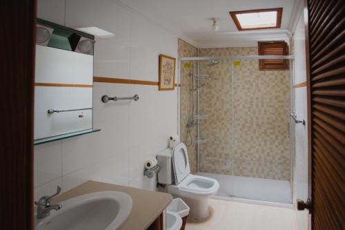 een badkamer met een toilet, een wastafel en een douche bij Bungalows Miami Beach in San Agustin