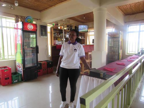 Eine Frau, die neben einem Tresen in einem Laden steht. in der Unterkunft Rebero Kivu Resort in Kibuye
