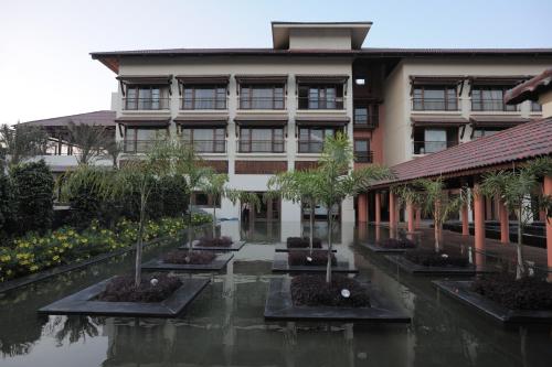a building with a courtyard with trees in front of it at Madhubhan Resort & Spa in Anand