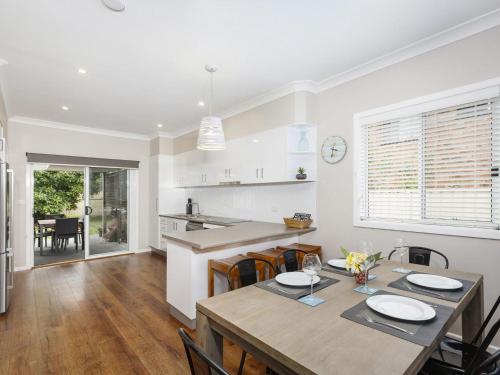 a kitchen and dining room with a table and chairs at Sandy Toes in Forster