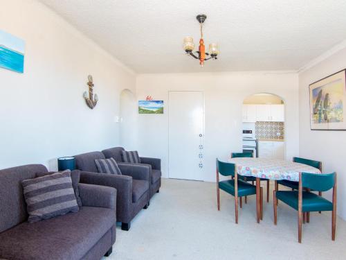 a living room with a couch and a table and chairs at Seabreeze 4 Opposite Bowling Club in Tuncurry