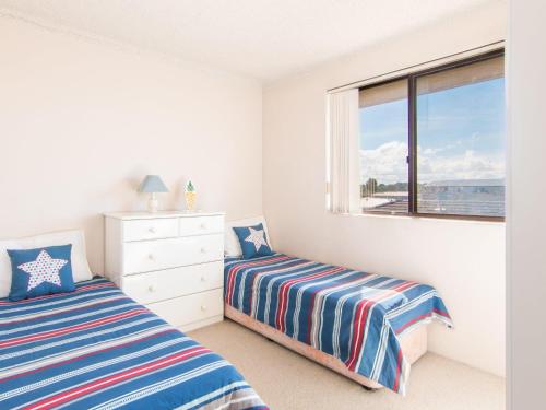 a bedroom with two twin beds and a window at Seabreeze 4 opposite the bowling club Tuncurry in Tuncurry