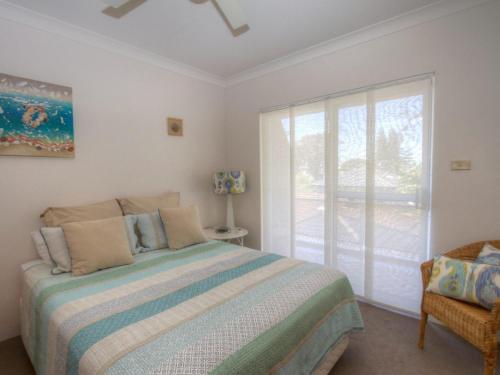 a bedroom with a bed and a sliding glass door at St James 6 in Tuncurry