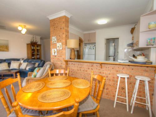 a kitchen with a wooden table and chairs in a room at St James 6 in Tuncurry