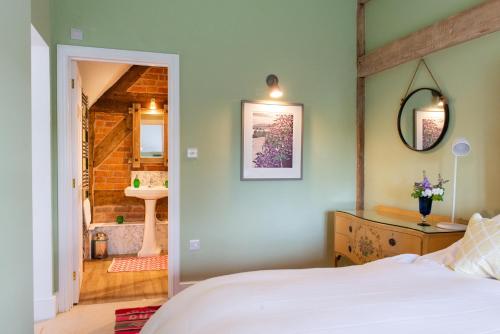 a bedroom with a bed and a bathroom at The Hayloft, Wall End Farm in Leominster