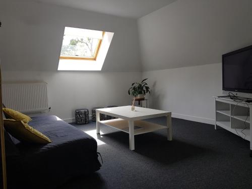 une chambre avec un lit, une table et une télévision dans l'établissement Appart dans grande demeure au calme, à Auzebosc