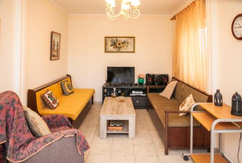 a living room with a couch and a tv at Tranquility House in Livadia