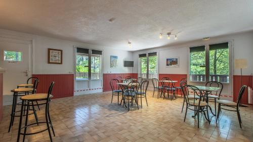 an empty room with tables and chairs in it at Vacancéole - Résidence Les Gorges Rouges in Guillaumes