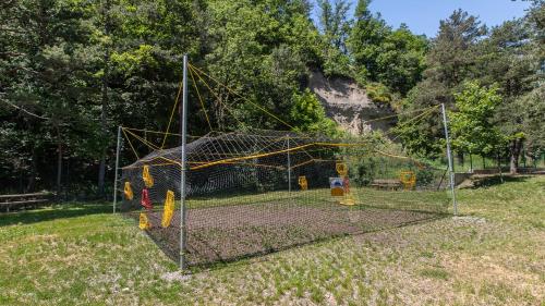 a net in a field with a playground at Vacancéole - Résidence Les Gorges Rouges in Guillaumes