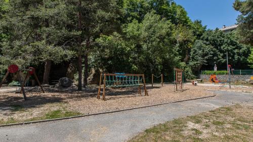 a park with a playground with a swing set at Vacancéole - Résidence Les Gorges Rouges in Guillaumes