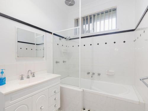 uma casa de banho branca com uma banheira e um lavatório em Wyvern em Forster