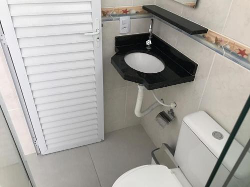 ein kleines Bad mit WC und Waschbecken in der Unterkunft Kitnet in Ubatuba