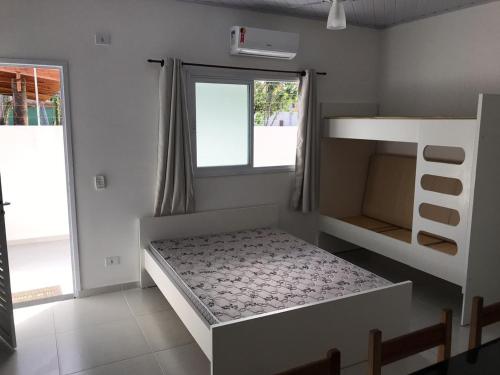 ein Schlafzimmer mit einem Bett und einem Etagenbett in der Unterkunft Kitnet in Ubatuba