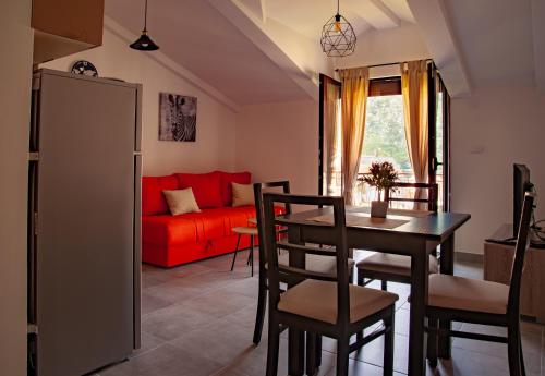 uma sala de estar com um sofá vermelho e uma mesa em Rooms & Apartments Vukasović em Kotor