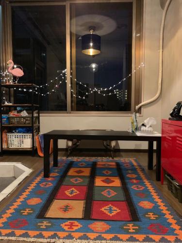 a living room with a table and a rug at 777 Takamatsu Guest House in Takamatsu