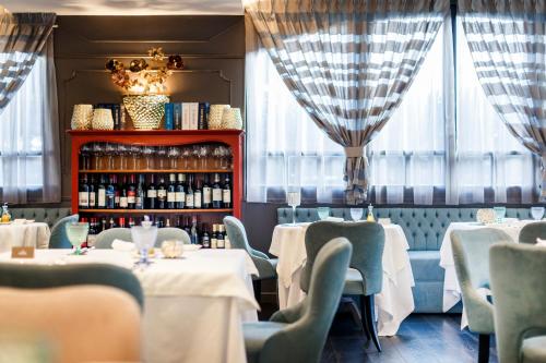 a restaurant with tables and chairs and a shelf of wine bottles at Hotel Spinale in Madonna di Campiglio