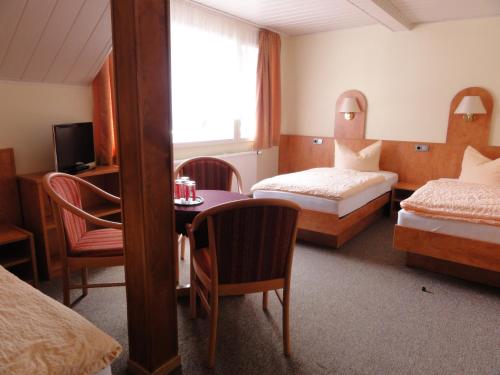 Habitación de hotel con 2 camas y mesa en Hotel Garni Melchendorf en Erfurt
