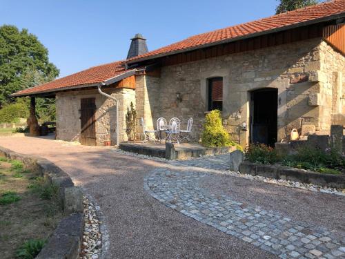 a stone house with two chairs and a driveway at Landkulturhof Glücksbringer in Rudolstadt
