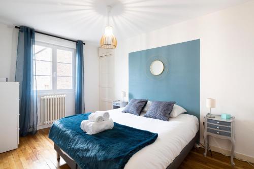 une chambre avec un grand lit avec un mur bleu dans l'établissement Moka by Cocoonr, à Rennes