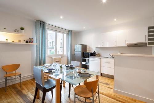 une cuisine avec une table et des chaises dans une pièce dans l'établissement Moka by Cocoonr, à Rennes