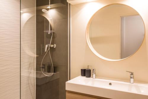 une salle de bain avec un lavabo et un miroir dans l'établissement L'Opéra - Bel appartement au pied du Capitole, à Toulouse