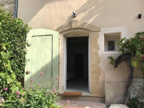 una entrada a una casa con una puerta verde en Studio Chambre voutée en Provence, en La Bastidonne