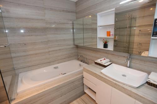 a bathroom with a tub and a sink at HNC Premier Hotel & Residences in Hanoi