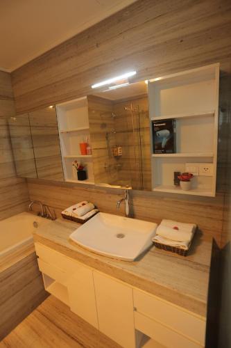 a bathroom with a sink and a large mirror at HNC Premier Hotel & Residences in Hanoi