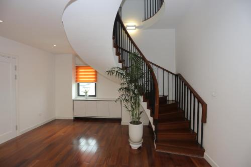 a staircase with a potted plant in a room at HNC Premier Hotel & Residences in Hanoi