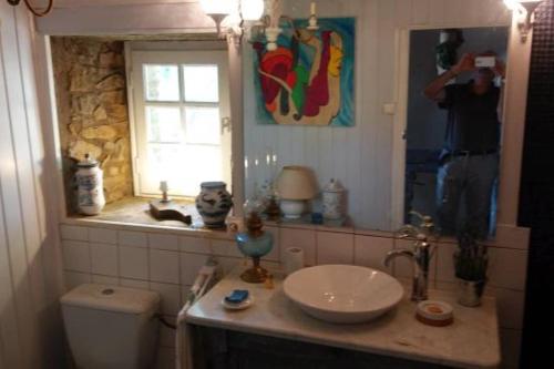 un homme prenant une photo d'une salle de bains avec lavabo dans l'établissement Casteljosse - nature calme et sérénité, à Viala-du-Tarn