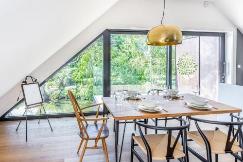 a dining room with a table and chairs and a large window at The Loft : Luxury Countryside Retreat for Family & Friends in Clipston