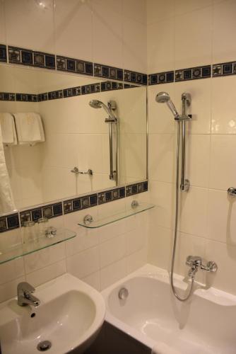 a white bathroom with a sink and a shower at Arbes in Prague