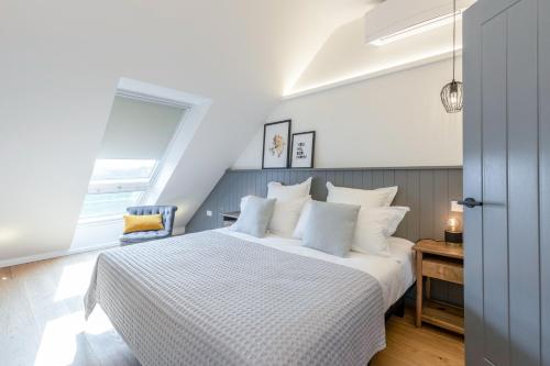 a bedroom with a large white bed and a window at The Loft : Luxury Countryside Retreat for Family & Friends in Clipston
