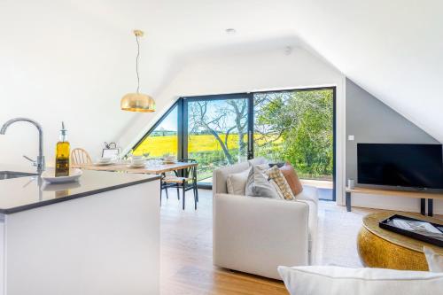 a kitchen and living room with a large window at The Loft : Luxury Countryside Retreat for Family & Friends in Clipston