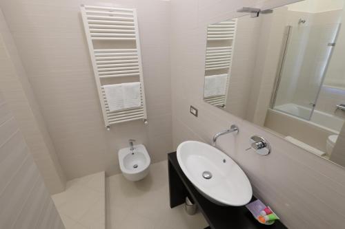 a white bathroom with a sink and a toilet at B&B Dimora del Duomo in Benevento