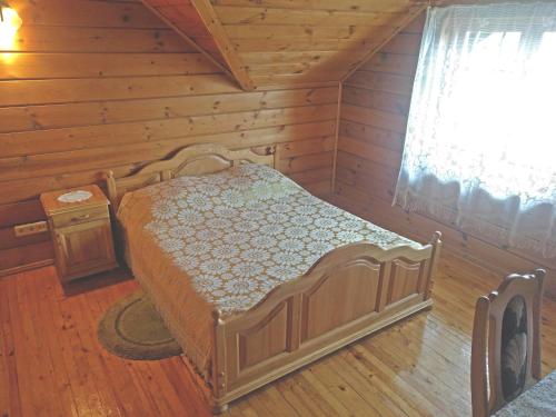 a bedroom with a bed in a log cabin at Pas Medžiotoją Motelis in Kryžkalnis