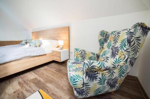 ein Schlafzimmer mit einem Bett, einem Stuhl und einem Bett in der Unterkunft Apartament Miejski in Wisła