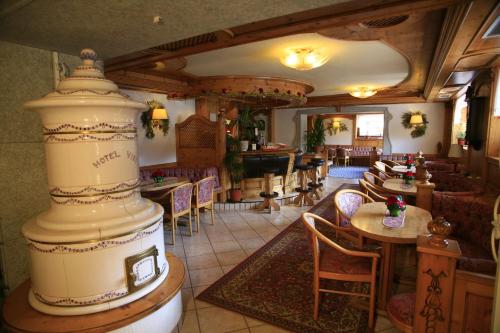 a restaurant with a large room with tables and chairs at Alpen Hotel Vidi in Madonna di Campiglio