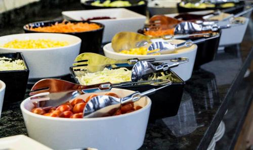 a buffet with many bowls of food on a table at Hotel & Spa Entremares in La Manga del Mar Menor