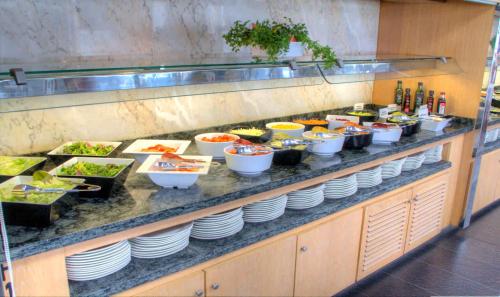 a buffet line with bowls and plates of food at Hotel & Spa Entremares in La Manga del Mar Menor