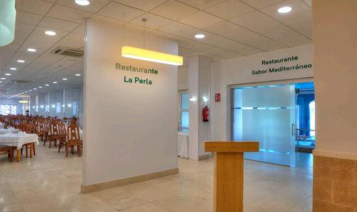 a restaurant with tables and chairs and a sign that says restaurant lab table at Hotel & Spa Entremares in La Manga del Mar Menor