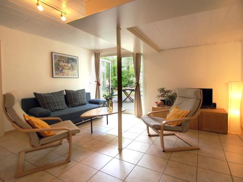 a living room with a blue couch and chairs at Ferienwohnung am Dümmer See in Dümmer