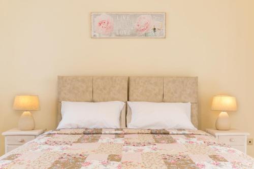 a bedroom with a large bed with two lamps at MarGreCo in Garitsa in Corfu