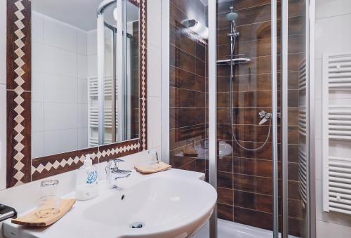 a bathroom with a sink and a shower at Panorama Hotel Guggenbichl - inkl Sommerkarte, einmaliger Eintritt ins Tauern Spa & bester Ausblick über Kaprun in Kaprun