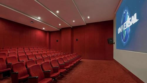 an empty auditorium with red chairs and a screen at Akka Antedon Hotel - Premium Ultra All Inclusive in Beldibi