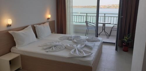 a bed with towels on it with a balcony at HARMONY in Sozopol