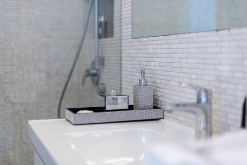 a bathroom with a sink with a soap dispenser on it at Apartament Sensual SAUNA&JACUZZI Poznań Stare Miasto in Poznań
