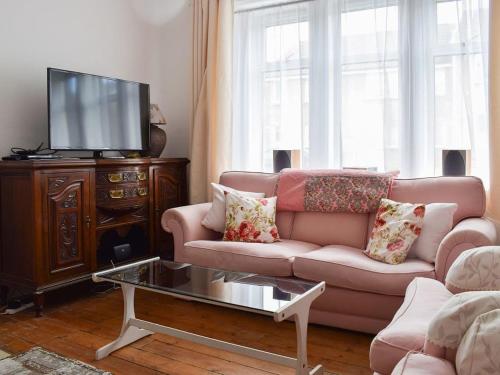 a living room with a couch and a tv at Brims cottage in Aberfeldy