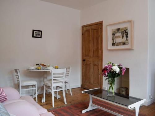 a living room with a table and a vase of flowers at Brims cottage in Aberfeldy