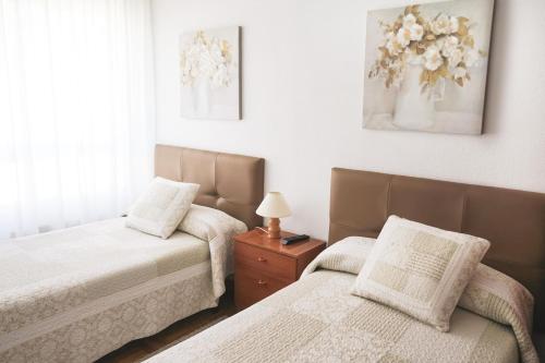 1 dormitorio con 2 camas y mesa con lámpara en Piso turístico Belisa en Lerma